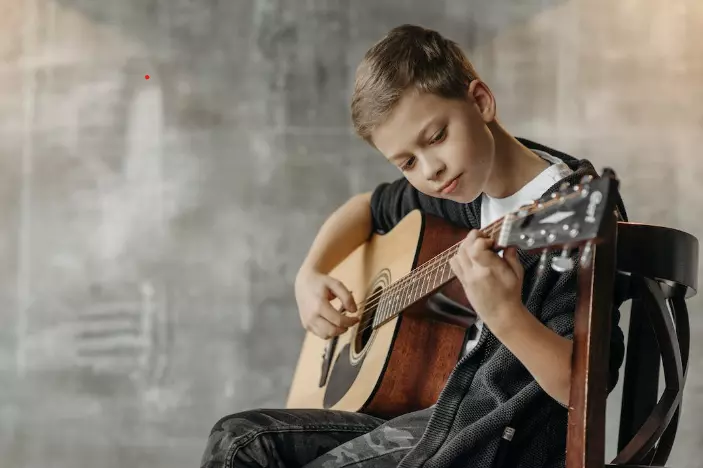 boy playing acoustic guitar
